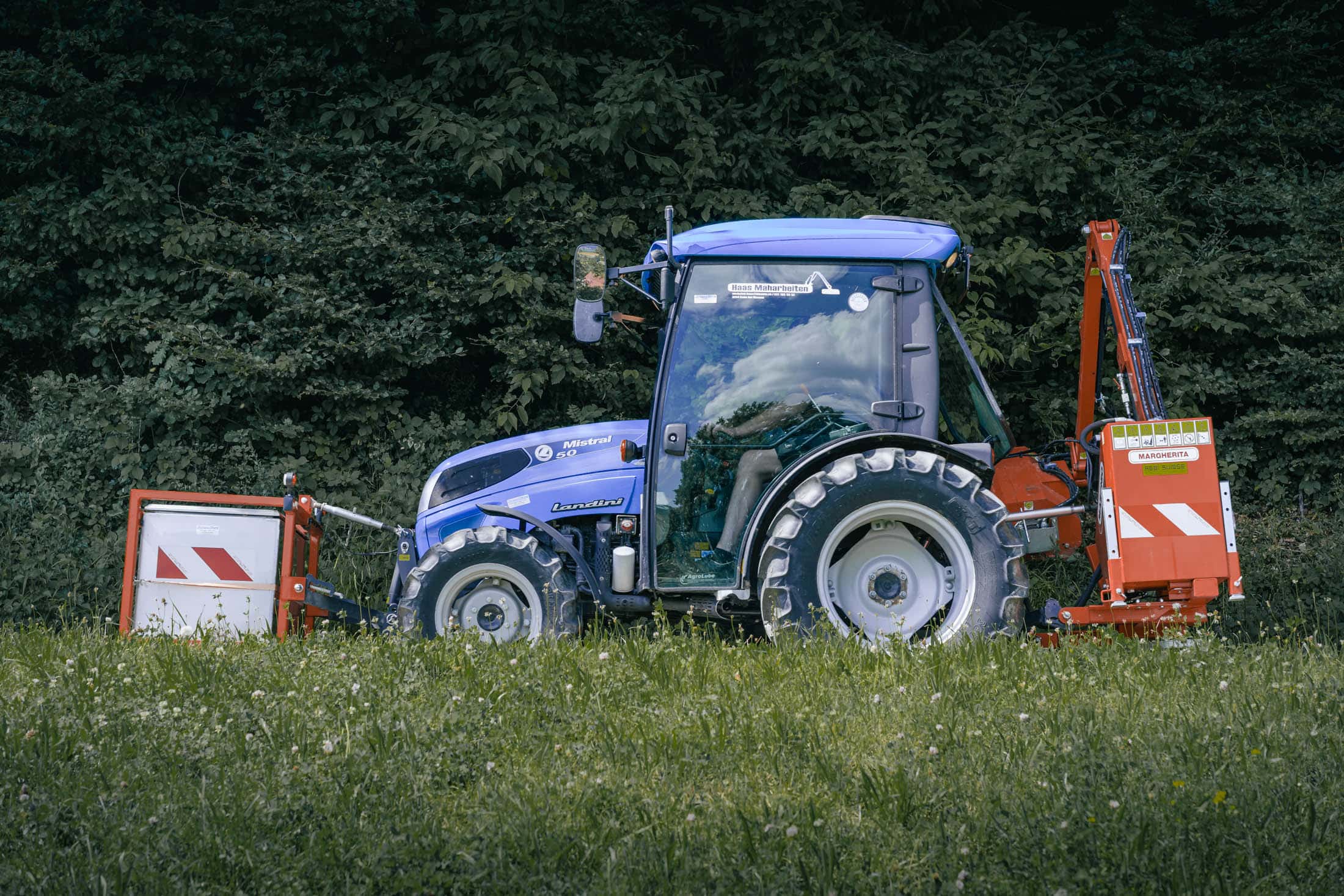 Mäharbeiten - Traktor mit Schwenkarm Seitenansicht